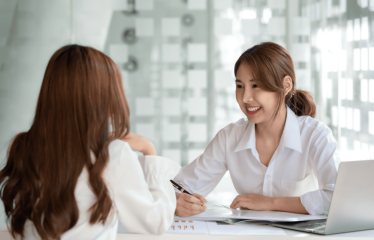 2 người đang ngồi trao đổi, tư vấn cho nhau nghe